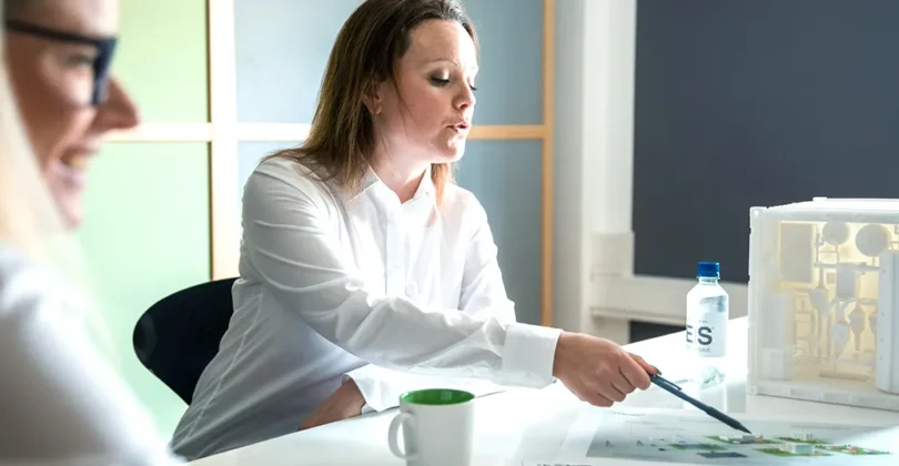 Two Energy Save colleagues discussing product development in meeting.